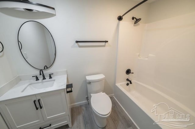 full bathroom featuring baseboards, toilet, vanity, wood finished floors, and bathing tub / shower combination