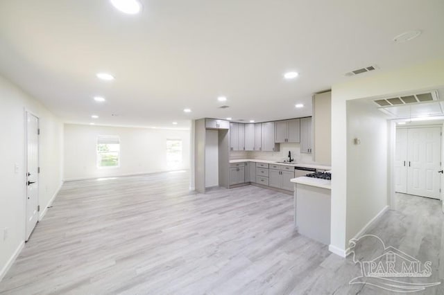 kitchen featuring gray cabinets, light wood-style flooring, visible vents, and baseboards