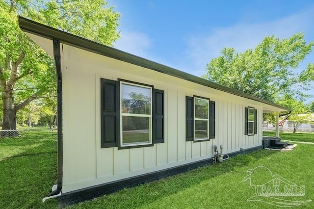 view of side of property featuring board and batten siding and a lawn
