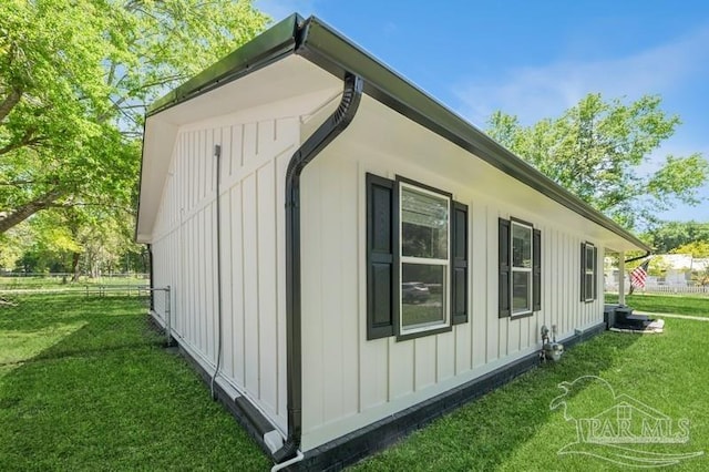 view of side of property featuring board and batten siding and a yard