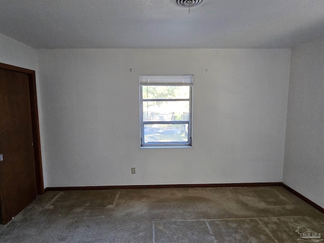 spare room featuring dark carpet