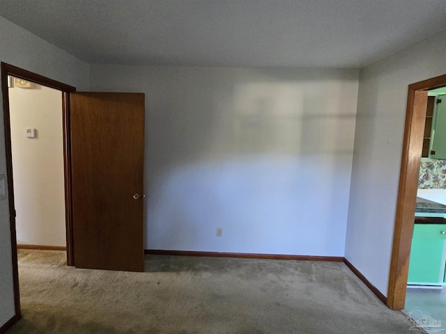 unfurnished room with carpet and a textured ceiling