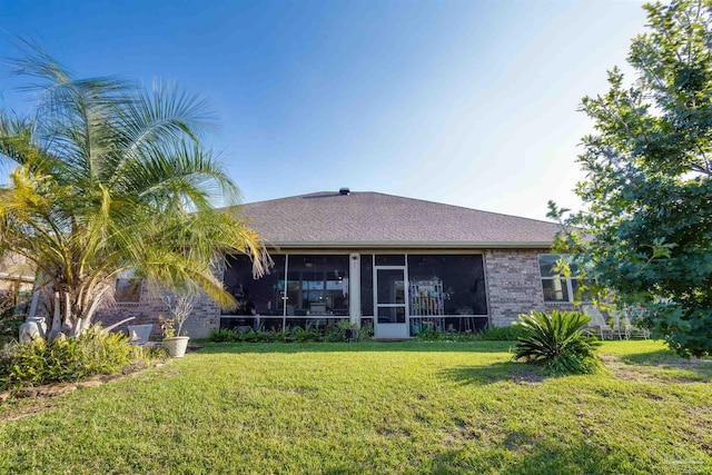 back of house featuring a sunroom and a lawn