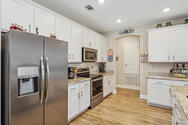 kitchen featuring light stone counters, stainless steel appliances, light wood-type flooring, and white cabinetry