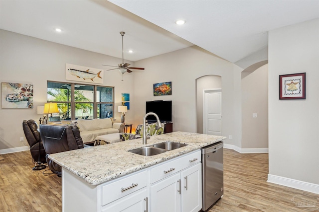 kitchen with light hardwood / wood-style flooring, a center island with sink, sink, white cabinets, and stainless steel dishwasher