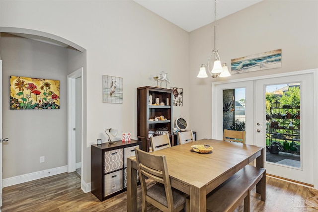 dining room with hardwood / wood-style flooring, a notable chandelier, and french doors