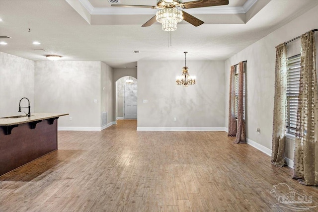 6372 Ladera Trl, Pace, FL 32571 - unfurnished living room with arched walkways, a sink, a ceiling fan, wood finished floors, and ornamental molding