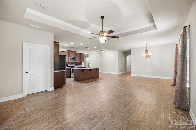 6372 Ladera Trl, Pace, FL 32571 - unfurnished living room with a tray ceiling, ceiling fan, a chandelier, baseboards, and recessed lighting