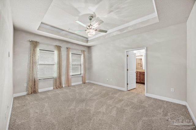 6372 Ladera Trl, Pace, FL 32571 - spare room featuring a raised ceiling, light carpet, ceiling fan, and baseboards