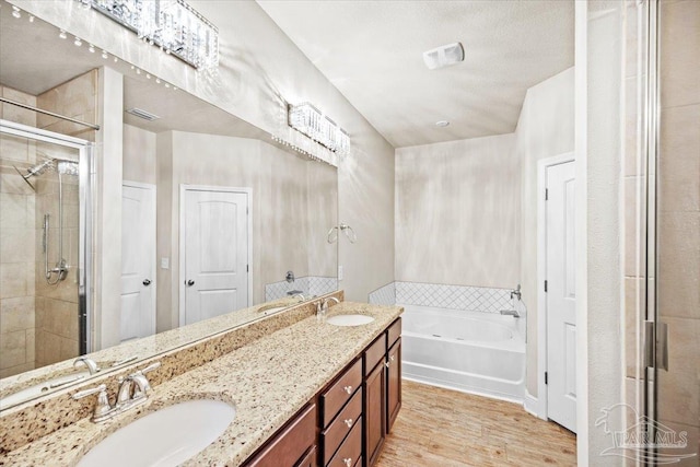 6372 Ladera Trl, Pace, FL 32571 - full bathroom with a stall shower, a bath, double vanity, and wood finished floors