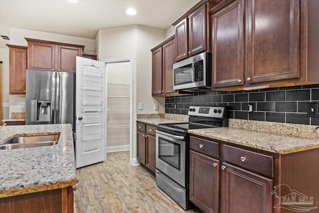 6372 Ladera Trl, Pace, FL 32571 - kitchen with appliances with stainless steel finishes, light wood-type flooring, tasteful backsplash, light stone countertops, and recessed lighting