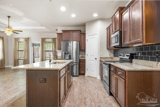 6372 Ladera Trl, Pace, FL 32571 - kitchen featuring stainless steel appliances, a sink, light wood-type flooring, a ceiling fan, and backsplash