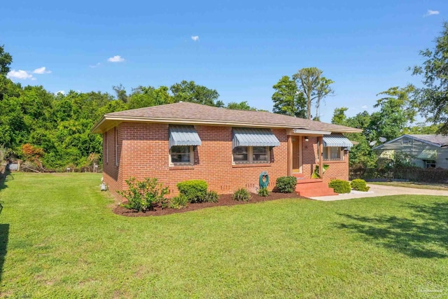 ranch-style home with a front yard and brick siding