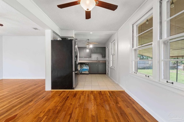 kitchen featuring a textured ceiling, gray cabinetry, stainless steel refrigerator with ice dispenser, light wood finished floors, and crown molding