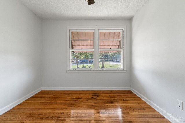 unfurnished bedroom featuring ceiling fan, dark wood-type flooring, and a textured ceiling