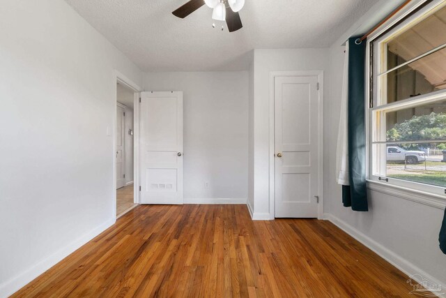 spare room with a wealth of natural light, dark hardwood / wood-style flooring, and a textured ceiling