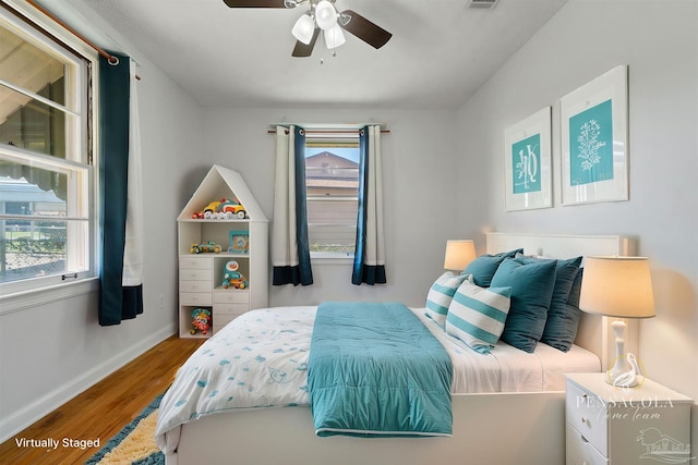 bedroom with visible vents, multiple windows, light wood-style flooring, and baseboards