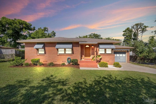 ranch-style house featuring an attached garage, brick siding, driveway, and a front lawn