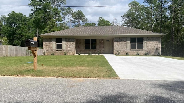 ranch-style house featuring brick siding, a shingled roof, fence, and a front yard