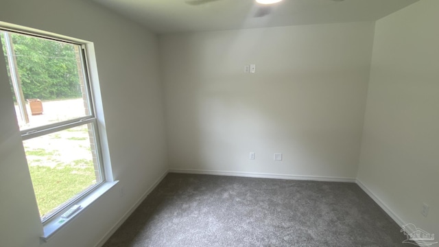 unfurnished room with a ceiling fan, baseboards, and carpet