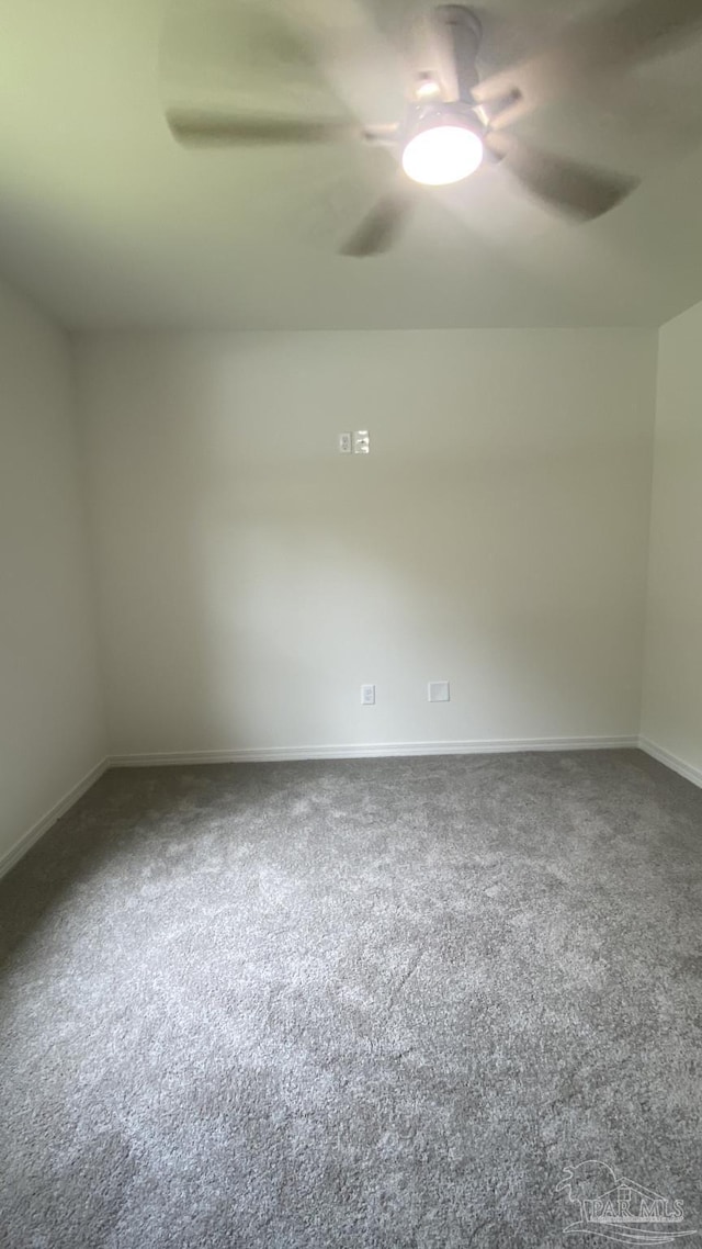 empty room with baseboards, ceiling fan, and carpet