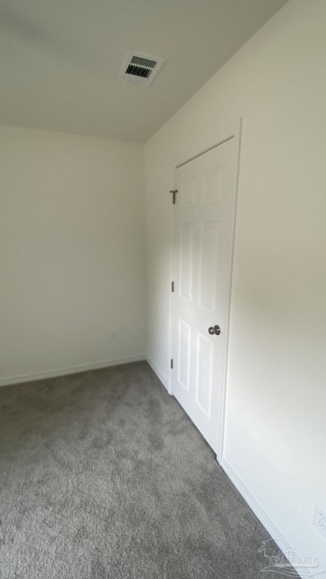 unfurnished room with carpet floors, baseboards, and visible vents