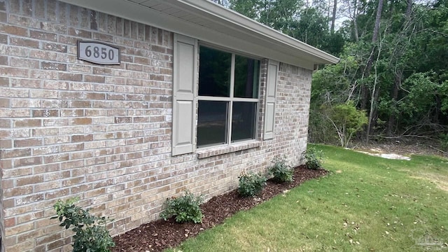 view of home's exterior featuring a lawn and brick siding