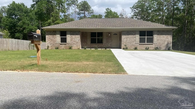 ranch-style home featuring fence, a shingled roof, brick siding, and a front yard