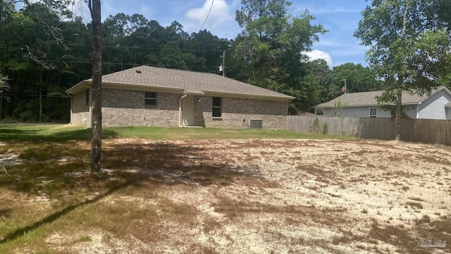 back of property with fence, a yard, and brick siding