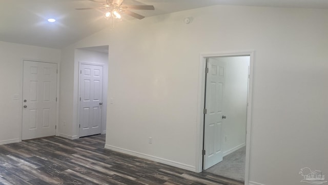 unfurnished room featuring a ceiling fan, baseboards, vaulted ceiling, and dark wood-style floors