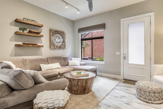 living area featuring a ceiling fan, light wood-style flooring, and rail lighting