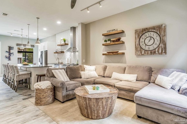 living room with recessed lighting, light wood-type flooring, visible vents, and track lighting