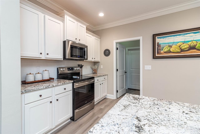 kitchen with light hardwood / wood-style floors, stainless steel appliances, crown molding, light stone counters, and white cabinets