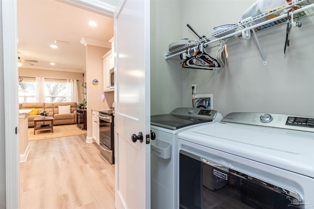 clothes washing area with ceiling fan, ornamental molding, separate washer and dryer, and light hardwood / wood-style flooring