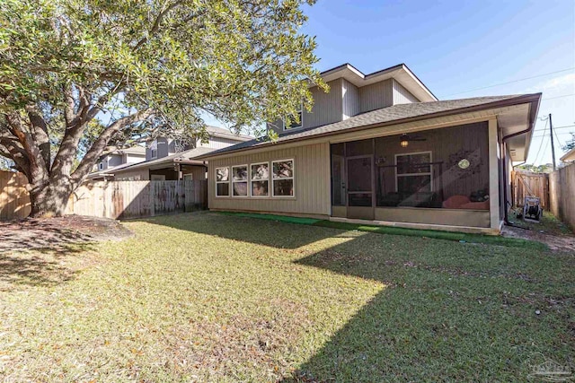 rear view of house featuring a lawn and a sunroom