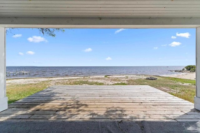 wooden deck featuring a view of the beach and a water view