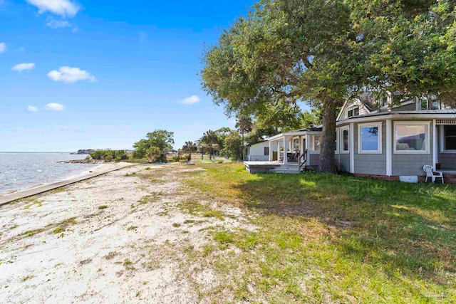view of yard with a beach view and a water view