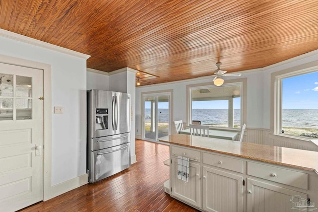 kitchen featuring wooden ceiling, ornamental molding, stainless steel fridge, and plenty of natural light