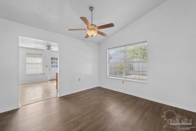 spare room with dark wood-type flooring, plenty of natural light, ceiling fan, and lofted ceiling