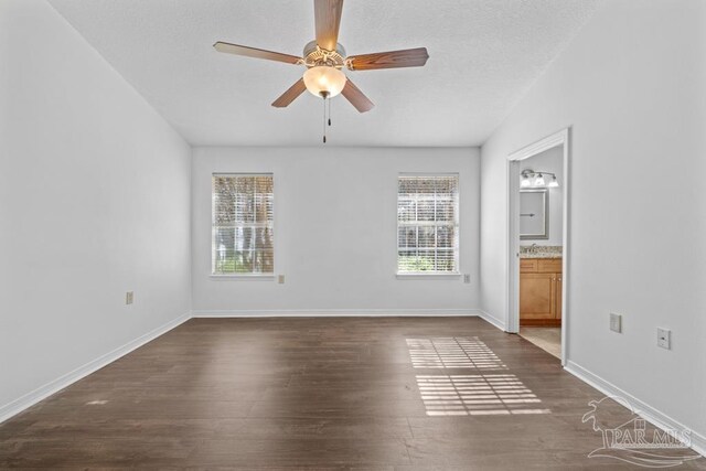 spare room with ceiling fan and dark wood-type flooring