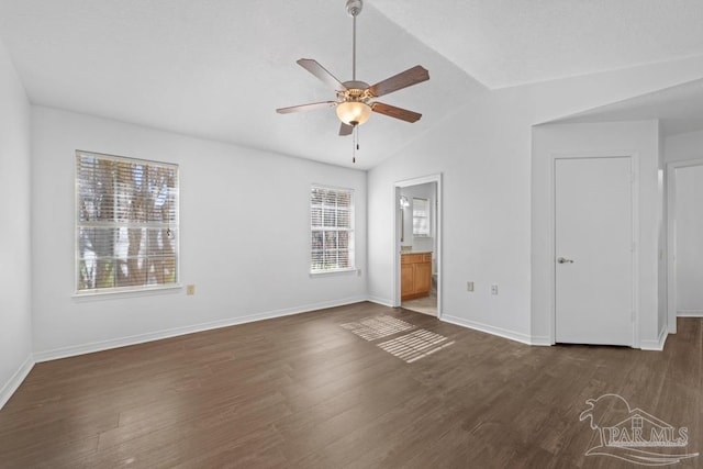 unfurnished bedroom featuring multiple windows, ceiling fan, dark hardwood / wood-style flooring, and vaulted ceiling