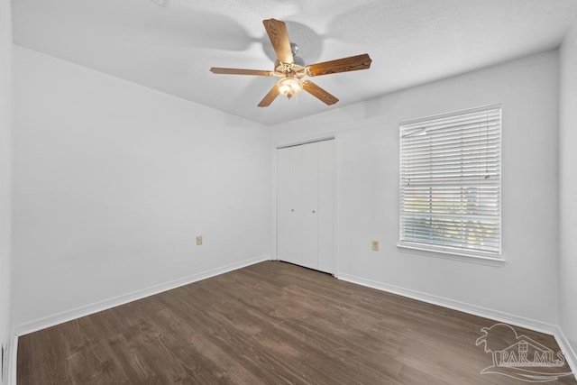 empty room featuring ceiling fan and dark wood-type flooring