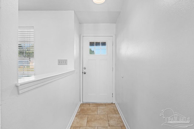 doorway to outside with light tile patterned floors