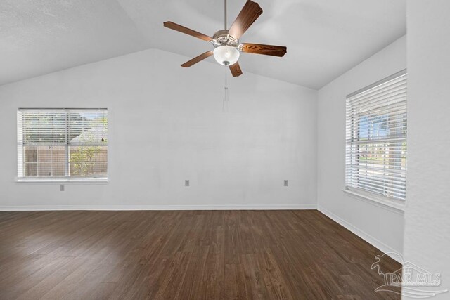 spare room with vaulted ceiling, ceiling fan, and dark wood-type flooring