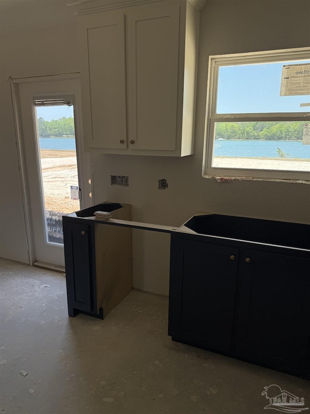 kitchen featuring concrete flooring and white cabinetry