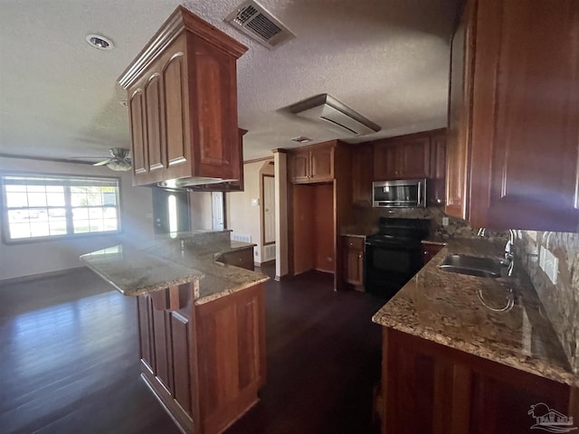 kitchen with black electric range oven, sink, ceiling fan, light stone counters, and kitchen peninsula