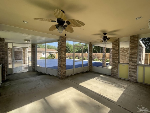 unfurnished sunroom featuring ceiling fan