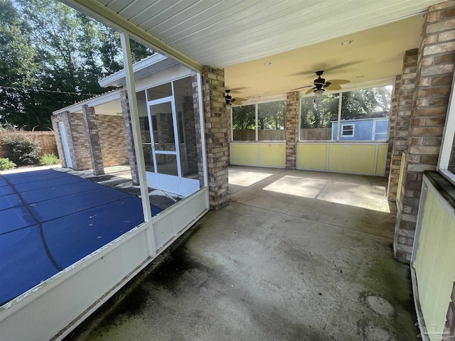 unfurnished sunroom featuring ceiling fan