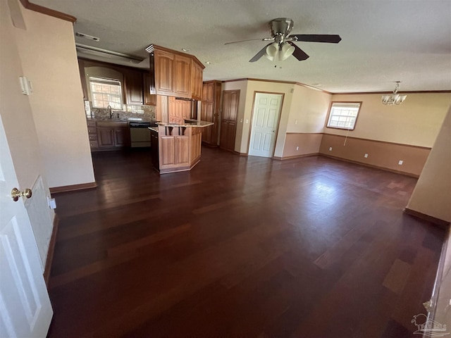 kitchen with sink, dark wood-type flooring, ornamental molding, and dishwasher