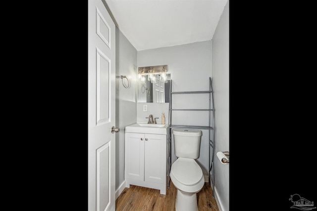 bathroom featuring hardwood / wood-style flooring, vanity, and toilet